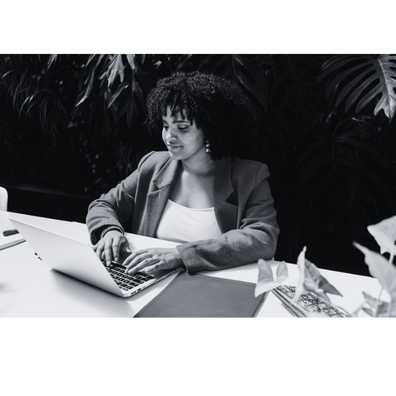 Young woman sitting at laptop working on her digital product business